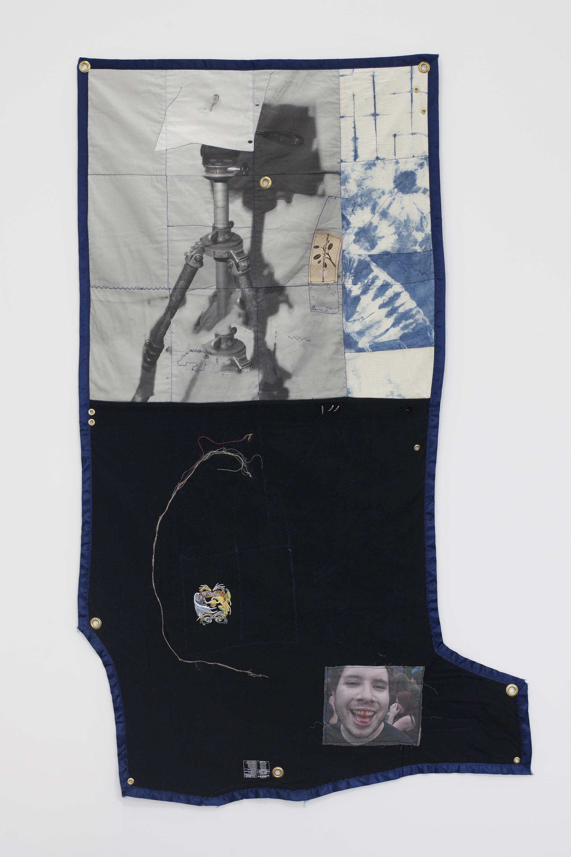 Erin Jane Nelson Dullup, 2014 ￼￼Inkjet on cotton, indigo-dyed muslin, 5XL t- shirt, contents of a USB cord,  silk ribbon, iron- on patch, dragon claw studs, coffee cozy, and quilt batting