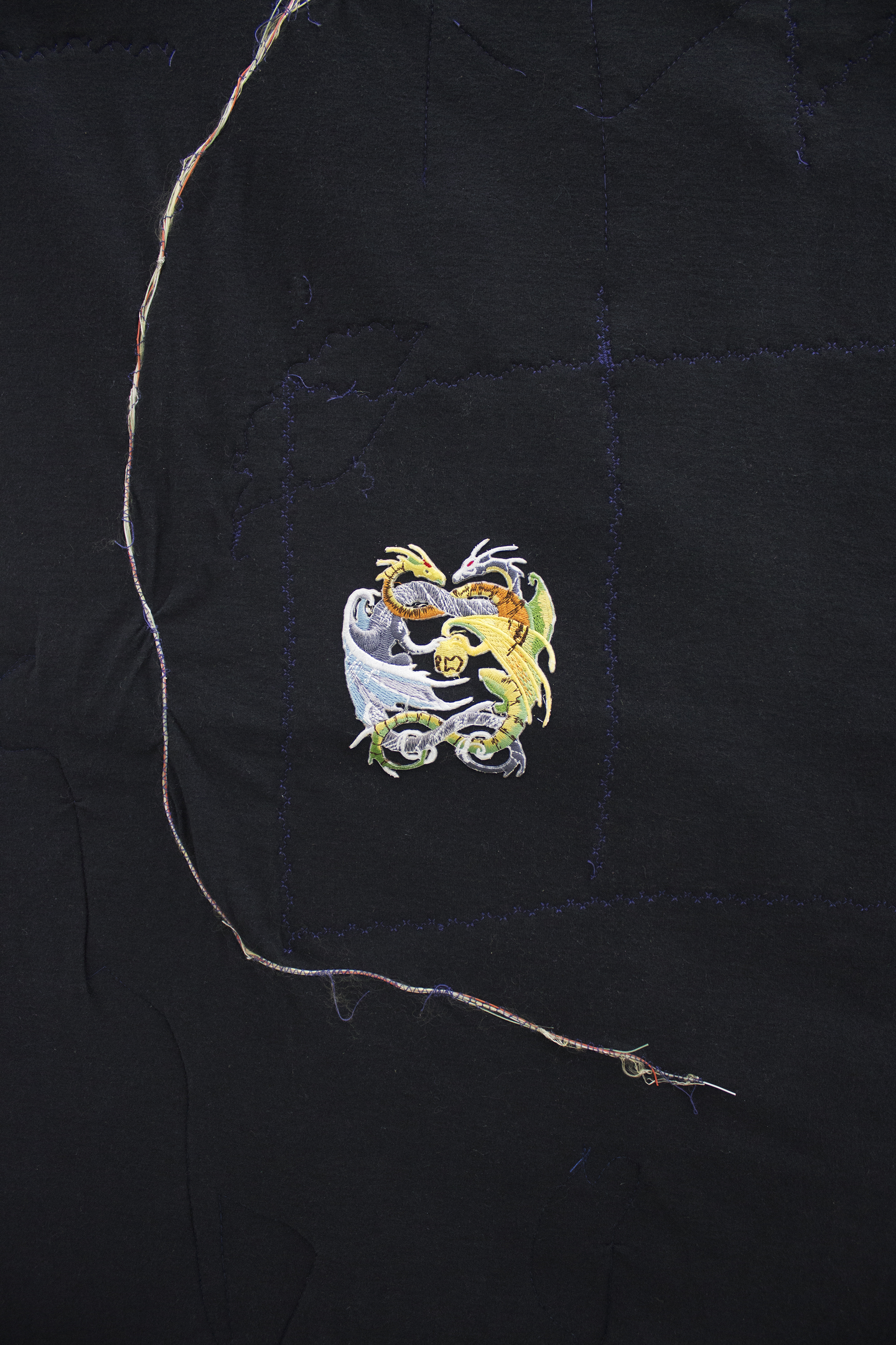 Erin Jane Nelson Dullup (Detail), 2014 ￼￼Inkjet on cotton, indigo-dyed muslin, 5XL t- shirt, contents of a USB cord,  silk ribbon, iron- on patch,  dragon claw studs, coffee cozy, and quilt batting